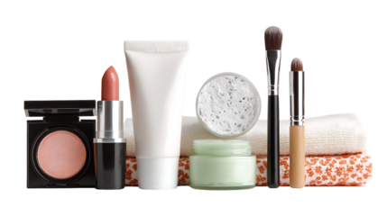 Beauty products and makeup brushes on a white surface with colorful towels isolated on transparent background