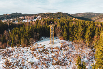 Plakat Svetly vrch lookout tower stands tall in Albrechtice. Surrounded by snow and trees, it offers a view of the Jizera mountains. People can explore nature and enjoy the winter scene.