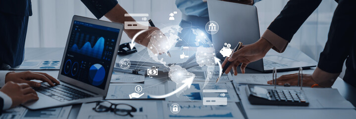 Team of diverse professionals analyzing data on laptops in a modern office setting, showcasing a digital connection to global business and innovation strategies. Trope