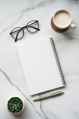 A stylish desk setup featuring a blank notebook on top of striped paper, glasses, a cup of coffee, a small wrapped gift, and seasonal decorations, perfect for holiday planning and creative work