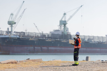 Worker work at a port with a cargo ship in the background