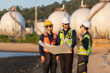 Fototapeta premium Petroleum engineers having a discussion near oil storage tanks