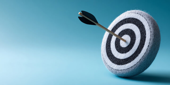A dart arrow hitting the bullseye of a target, symbolizing success or achievement in business goals and objectives
