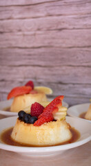 Imagen horizontal de flan napolitano en peque&ntilde;os paltos con frutos rojos