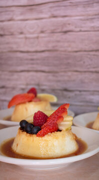 Imagen horizontal de flan napolitano en peque&ntilde;os paltos con frutos rojos