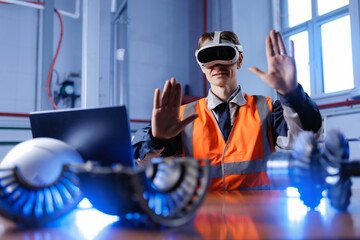Caucasian male engineer using computer and vr for machinery inspection in industrial setting