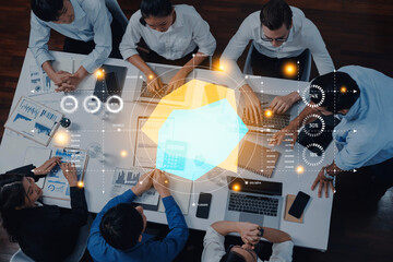 A diverse team collaborates in a modern office setting, utilizing laptops and engaging with data charts to drive strategic business decisions and foster teamwork. Trope