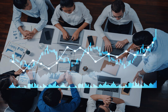 A diverse business team engages in dynamic collaboration, analyzing financial data and strategizing in a modern office environment with advanced technology at hand. Scalp - Powered by Adobe