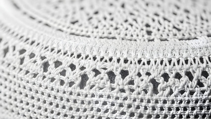 close up macro view of white knitted fabric with intricate lace patterns and open stitches