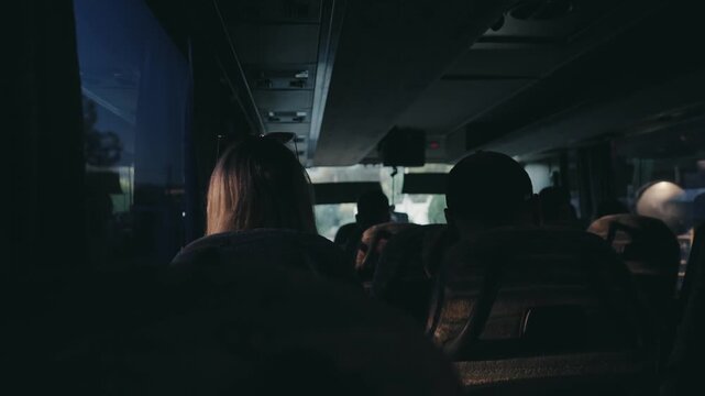 People travel on a big tourist bus. The bus rides along the mornings in the sunrise, slow motion