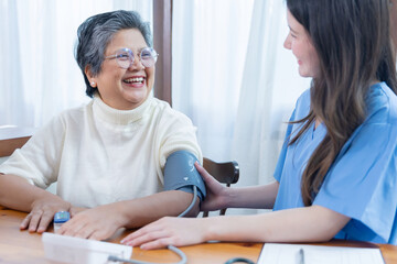 Healthcare worker checks blood pressure of older woman in clinic during health appointment