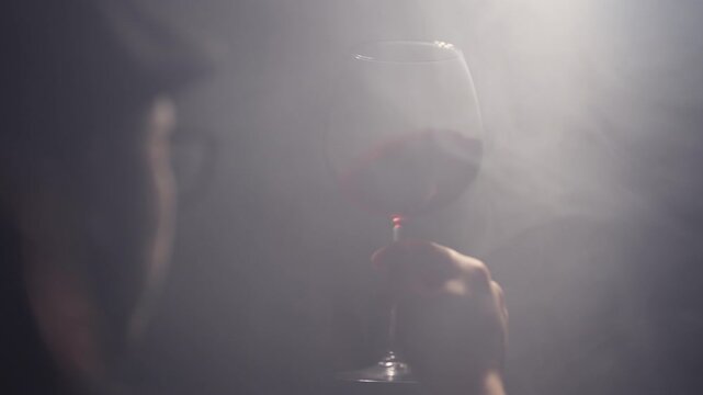 Sommeliers male with hat hold glass red wine tasting degustation card, Cinematic light scene with fog