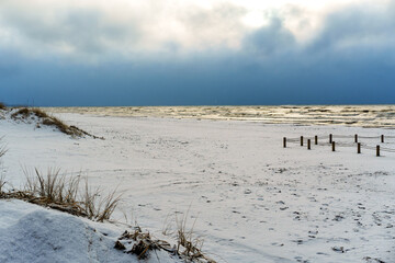 Snow Covered Beach under Dramatic Dark Sky with Sea Waves