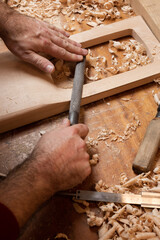 The carpenter grinds the blank of the tagelharpa with a file