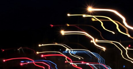 Linear composition. Аbstract long-exposure photograph depicting colorful neon light trails against a dark background.