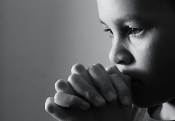 little boy praying to God with hands together with people stock image stock photo
