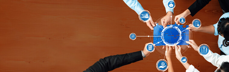 A dynamic scene of diverse professionals collaborating at a business strategy meeting, actively engaging over a circular diagram on a wooden table. Amity