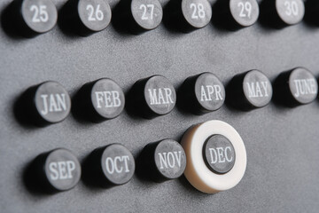 Month December on stylish black calendar, close up.