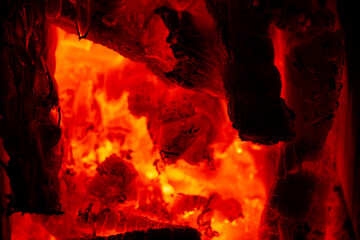 Glowing burning wood embers creating abstract texture