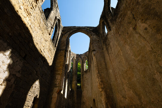 Gothic arches framing blue sky in the sunlit ruins of Oybin Monastery, part of the castle complex on Oybin mountain in Saxony, Germany