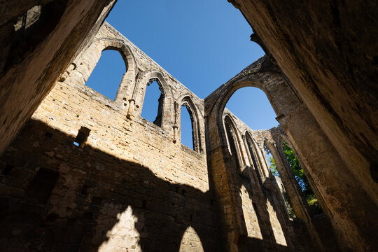 Gothic arches framing blue sky in the sunlit ruins of Oybin Monastery, part of the castle complex on Oybin mountain in Saxony, Germany