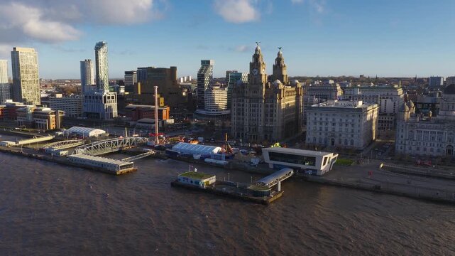 Aerial sunrise sweep over Liverpool Pier Head, River Mersey, Royal Liver Building, Cunard, Port of Liverpool, Museum of Liverpool, tents and fairground rides.