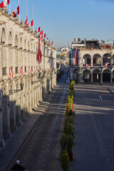 Naklejka premium The symmetry and brightness of the Plaza de Armas never cease to amaze. Between the white volcanic stone and the patriotic decorations, this view captures the essence of Arequipa’s heritage and its en