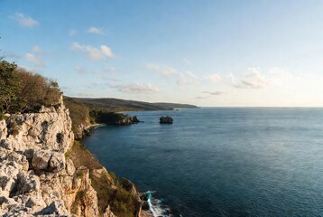 Panoramic view of a dramatic coastline with towering cliffs meeting the tranquil turquoise sea