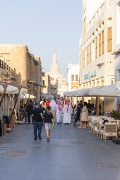 Doha, Qatar - 21 February 2025: View of people strolling through the vibrant Souq Waqif, where the traditional architecture meets modern life under a clear sky.