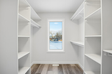 Fototapeta premium Small, empty walk in closet with a window
