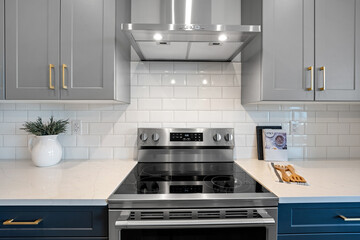 Stainless steel stove top with a white tile backsplash