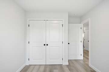 Fototapeta premium White bedroom with two doors and a wooden floor