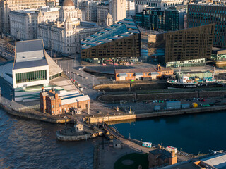 Aerial sunrise view of Liverpool waterfront shows Museum of Liverpool, Mann Island, Port of Liverpool Building, Albert Dock, and a moored vessel marked Liverpool.