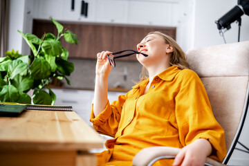 Woman accountant reading financial statement in home office with laptop. Careful tax review and bookkeeping control.