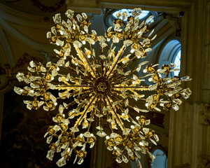Spectacular crystal and gilded bronze chandelier hanging within the ornate, high-arched interior of
