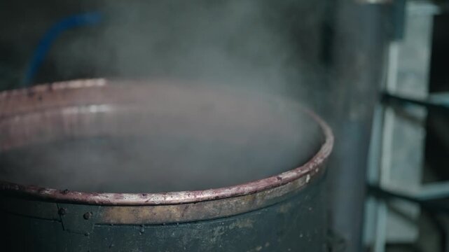 Steam evaporation out of a copper boiler in homemade distillery. Making moonshine schnapps, alcoholic beverages such as brandy, cognac, whiskey, bourbon, gin, and scotch, slow motion