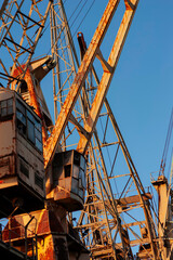 Close-up of oxidized harbor crane framework with cables and mechanical components