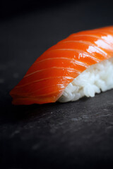 Salmon nigiri sushi close-up on black background