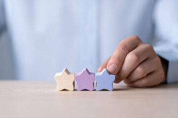 Pastel star hand wooden star rating concept close up evaluation