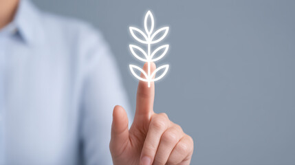 Finger touching glowing leaf icon symbolizing sustainable technology and eco innovation, close up of hand expressing care and connection with nature