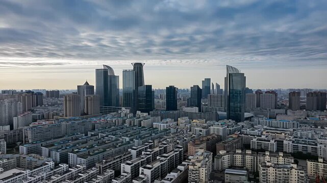 Wide hyperlapse shot of dense urban sprawl transitioning into modern high-rises under dramatic moving clouds, captured in dynamic forward motion. Concept of contemporary city growth