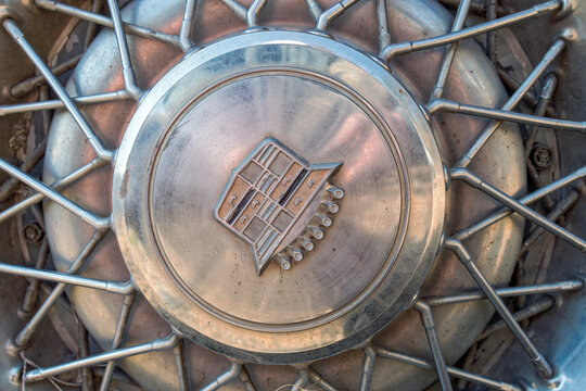 Oregon, USA - September 11, 2025: Detail of a wire hubcap and emblem on an abandoned 1967 Cadillac