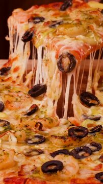 Dramatic cheese stretch over tasty pizza slice, Served hot with melted cheese and flavorful black olives