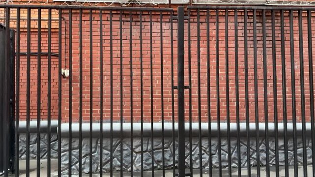 Metal Railing Atop Brick Wall CloseUp Tight Composition Highlighting Parallel Bars And Mortar Lines Subtle Weathering Horizontal Rhythm Muted Color Palette Architectural Detail