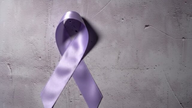 A single lavender ribbon symbolizes awareness on a textured gray background. The ribbon represents support, hope, and charity for important causes.