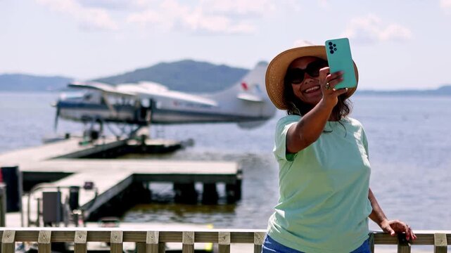 Happy smiling tourist taking selfie with seaplane