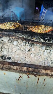 Street food vendor grilling fish on charcoal grill in Bali, Indonesia