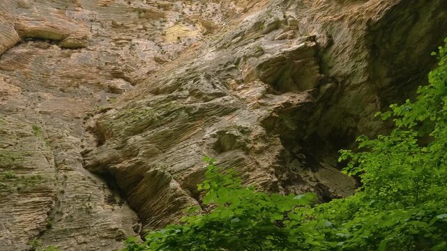 Scenic footage captures the stunning natural beauty of the Karchagsu Gorge in the Republic of Dagestan, Russia. The video showcases steep, rocky cliffs and vibrant green vegetation in the North Caucas
