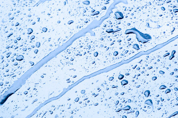 Raindrops clinging to the aluminum handrails. There is colorful bokeh in the background.