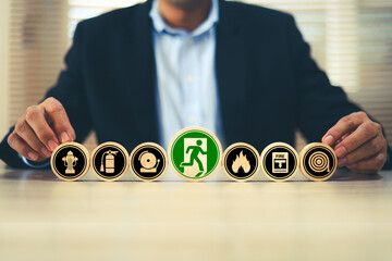 Hand chooses with door exit sing on wooden toy stack for fire escape to prevent with fire extinguisher and emergency prevention protection symbol for safety first and rescue and training concepts.